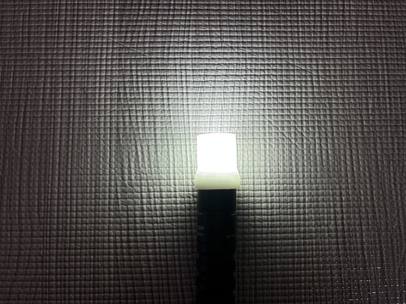 デュフューザーを装着し点灯している LUMINTOP EDC01 の写真