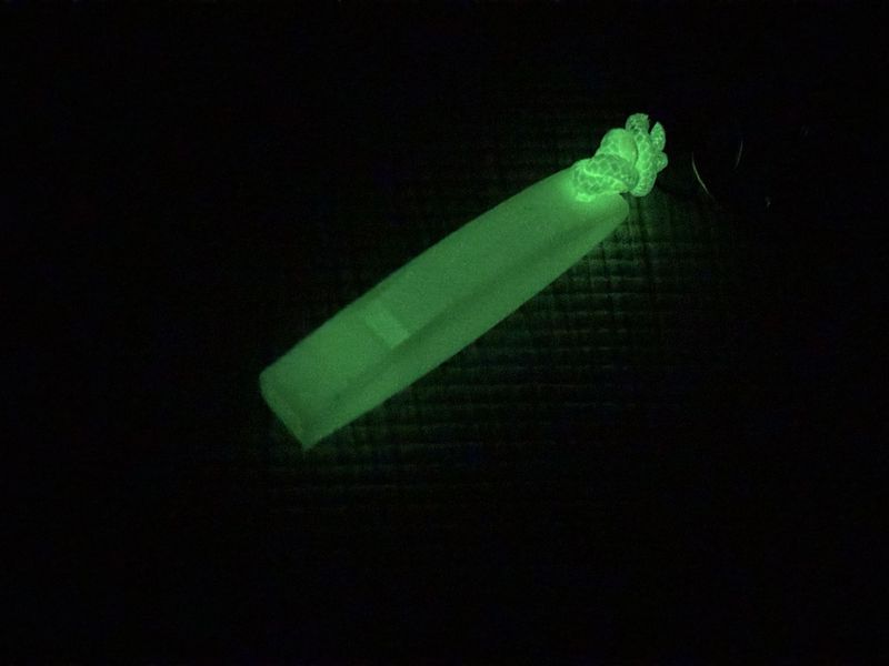 暗闇でぼんやり発光するMIYAGEN 3D WHISTLE 2g with GLOW。蓄光コードの方が強く光り、急な停電時のマーカーとして機能する様子。