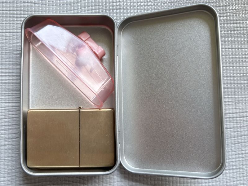 フラットトップのZIPPOとオイル計量カップを金属ケースに収めたところ