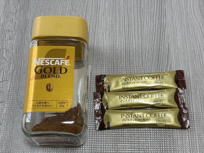 ネスカフェ ゴールドブレンドの瓶とスティックコーヒー3本を並べた様子